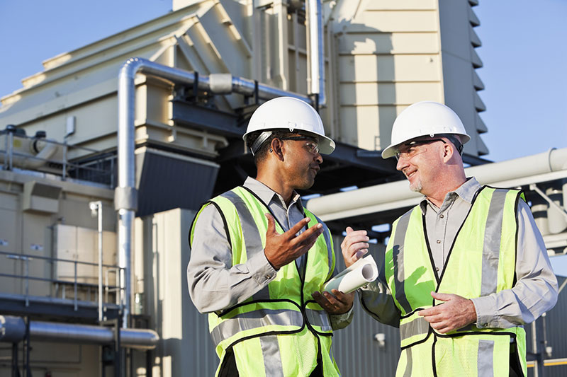 2 people talking outside power plant