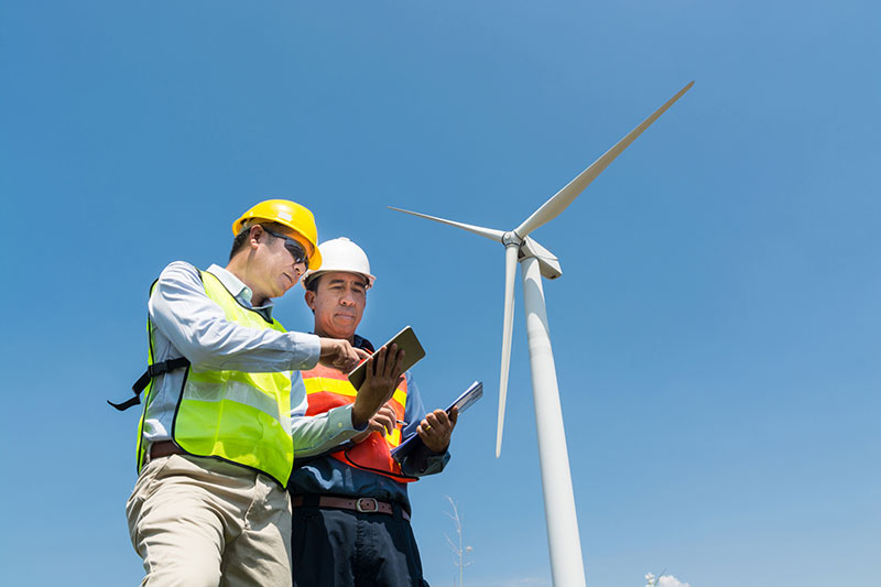Workers next to a wind turbine